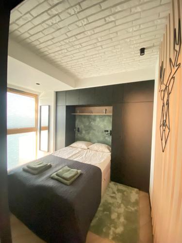 ein Schlafzimmer mit einem Bett mit zwei Handtüchern darauf in der Unterkunft Loft 22 DELUX in Wałcz