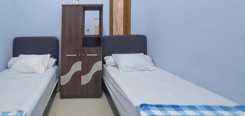 two beds sitting next to each other in a room at Griya Mbak Tafik Syariah in Gendingan