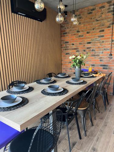 a long wooden table with chairs and plates on it at Dom z basenem Bałtów 22 in Bałtów