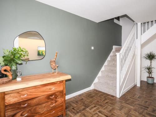 a room with a staircase with a mirror and a dresser at Y Goedwig in Llanfairpwllgwyngyll