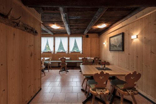 a dining room with wooden walls and tables and windows at ArlBerglife Ferienresort in Pettneu am Arlberg