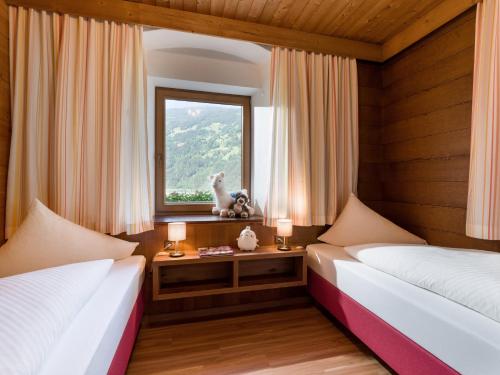 two beds in a room with a window at Aparthotel Gallahaus in Zell am Ziller