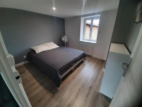 ein kleines Schlafzimmer mit einem Bett und einem Fenster in der Unterkunft Bel Appartement T2 40 M² in Vaugneray