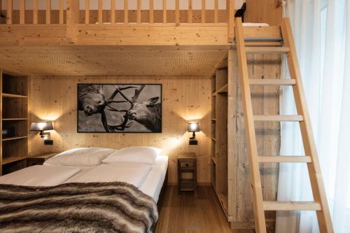 a wooden bunk bed with a ladder in a room at ArlBerglife Ferienresort in Pettneu am Arlberg
