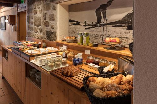 a kitchen with a buffet with bread and food at ArlBerglife Ferienresort in Pettneu am Arlberg