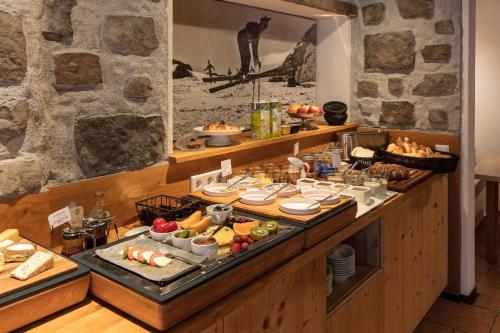 a buffet with a lot of food on a table at ArlBerglife Ferienresort in Pettneu am Arlberg