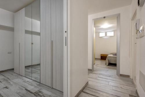 um quarto com paredes brancas e um corredor com um espelho em Solelio em Alghero