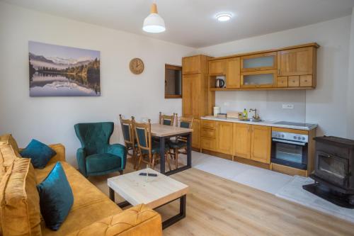 a kitchen and living room with a couch and a table at Monte Pino Lux Apartments in Žabljak