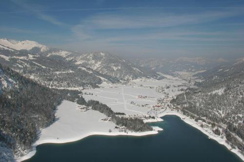 an aerial view of a lake and snow covered mountains at Chalet & Apartments Tiroler Bua in Achenkirch