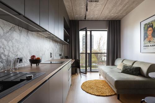 a living room with a couch and a kitchen at Rocca House by Larsen in Tallinn