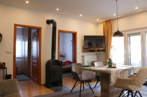 ein Wohnzimmer mit einem Holzofen und einem Tisch in der Unterkunft Nyugi-Lak in Lipót