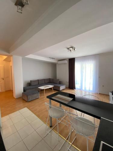 sala de estar con mesa, sillas y sofá en Aqua Blue Apartment, en Peštani