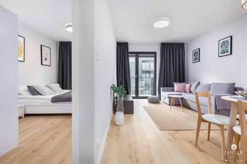 ein Wohnzimmer mit Sofa und Tisch in der Unterkunft KOŁOBrzegu Apartamenty by Jantar Apartamenty Kołobrzeg in Kołobrzeg