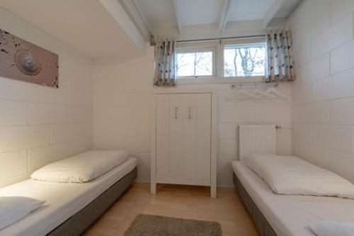 2 camas en una habitación pequeña con ventana en Wildrijk 83 Sint Maartenszee, en Sint Maartensvlotbrug