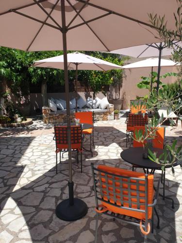a table and chairs with an umbrella on a patio at Athina résidence in Nydri