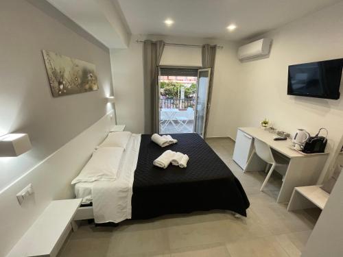 a bedroom with a bed and a desk and a television at Aedes Tropea B&B in Santa Domenica