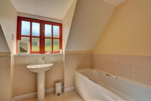 een badkamer met een wastafel en een bad bij 28 Barnes Meadow in Uplyme