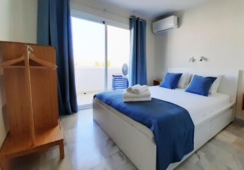 ein Schlafzimmer mit einem Bett und einem großen Fenster in der Unterkunft Balcón del Mar Estepona in Estepona