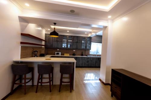 a kitchen with a island with bar stools at MAYA Residences Rwanda in Kigali