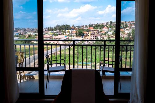 a balcony with two chairs and a view of a city at MAYA Residences Rwanda in Kigali