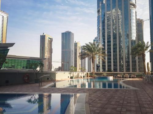 a pool in the middle of a city with tall buildings at HiGuests - Cozy Studio With Panoramic Views on the Lake in Dubai
