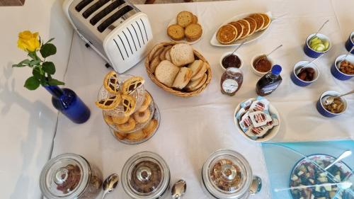 a table with breads and pastries and other foods at Villa Serenity B&B in Sannat