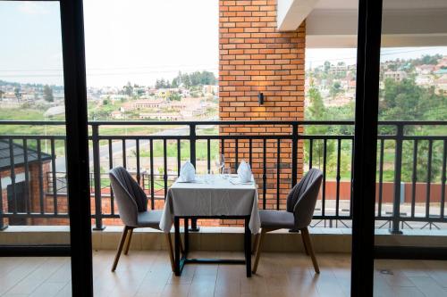a table and chairs in a room with a balcony at MAYA Residences Rwanda in Kigali