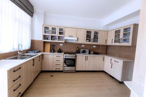 a kitchen with wooden cabinets and a sink at MAYA Residences Rwanda in Kigali