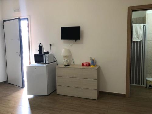 レヴェラーノにあるB&B Ornellaの冷蔵庫、壁掛けテレビが備わる客室です。