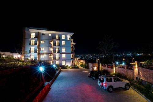 a white car parked in front of a building at night at MAYA Residences Rwanda in Kigali