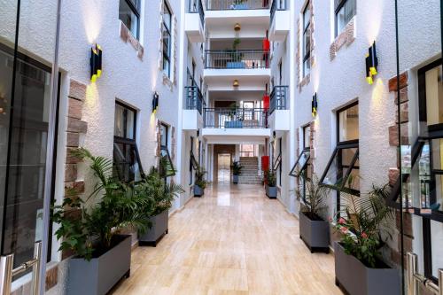 an empty hallway of an apartment building with potted plants at MAYA Residences Rwanda in Kigali