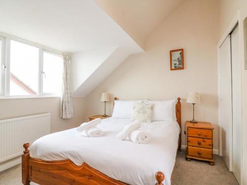 a bedroom with a bed with white sheets and a window at Seaview in Weymouth