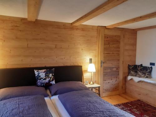 een slaapkamer met 2 bedden in een kamer met houten wanden bij Hüttenzauber in Taxenbach