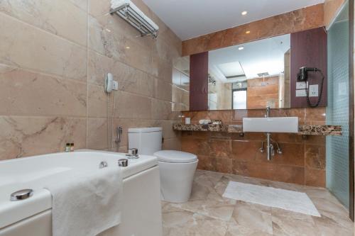 a bathroom with a tub and a toilet and a sink at Mahabir Palace in Kathmandu