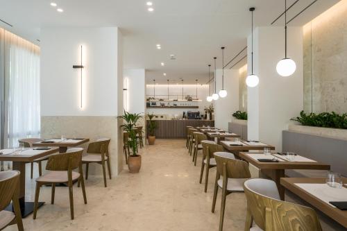 a restaurant with wooden tables and chairs and a counter at SanSal Boutique Hotel in Chania