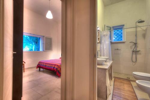 un bagno con lavandino, servizi igienici e un letto di Casa Vacanza Don Giulio 37 a Francavilla Fontana