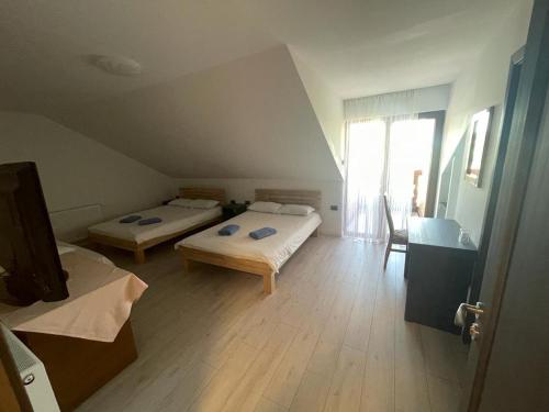 舒加塔格盐矿镇Pensiunea Cosău的客房设有两张床,铺有木地板。