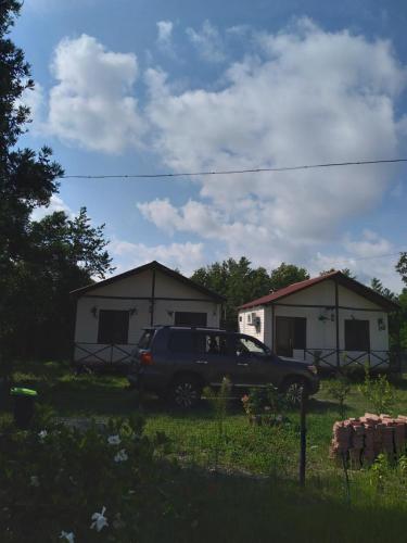a truck parked in a yard with two houses at Апарт-отель "У речки" in Kuchkisabano