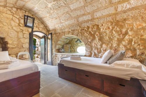 1 Schlafzimmer mit 2 Betten und einer Steinmauer in der Unterkunft Villa La Pajara in Santa Maria di Leuca