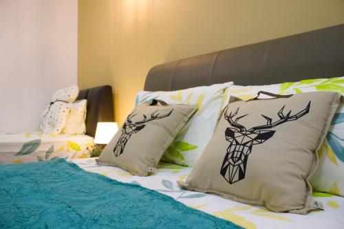 a bed with pillows with a deer on it at The FORUM condominium, Jalan Inai, Off Jalan Tun Razak in Kuala Lumpur