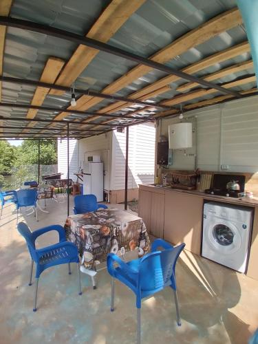 a living room with a table and chairs and a kitchen at Апарт-отель "У речки" in Kuchkisabano