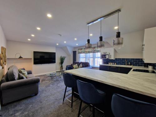 cocina y sala de estar con bar y sillas en DYSA Clifton Apartments, en Lytham St Annes