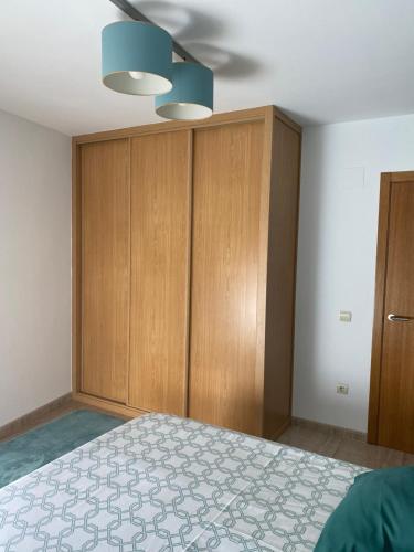 a bedroom with a bed and wooden cabinets at El Piset del Llangosti in Vinaròs