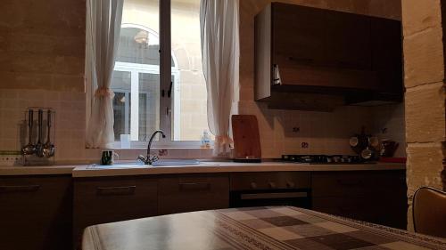 cocina con fregadero y ventana en Dar il-Hena en Żurrieq