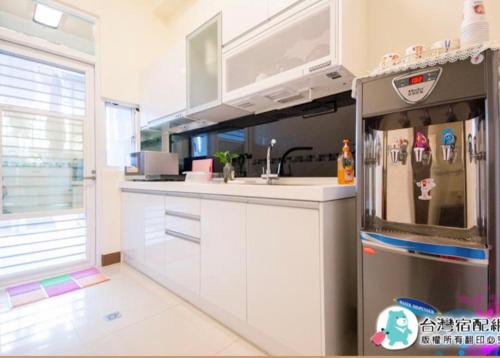 a kitchen with white cabinets and a refrigerator at Fei Ge B&B in Taitung City