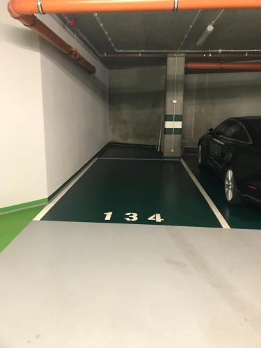 a parking garage with a car parked in it at Wiślane Tarasy 2.0, free parking, private garden in Kraków