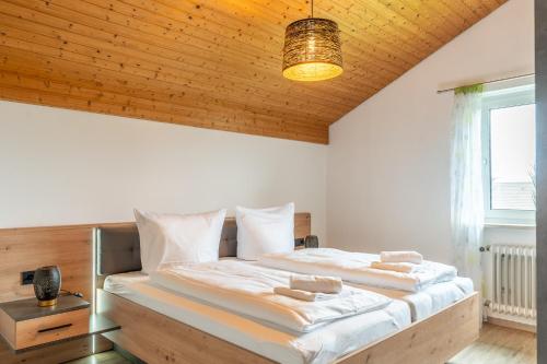 a bedroom with a large bed with a wooden ceiling at Haus Bergfink in Waltenhofen