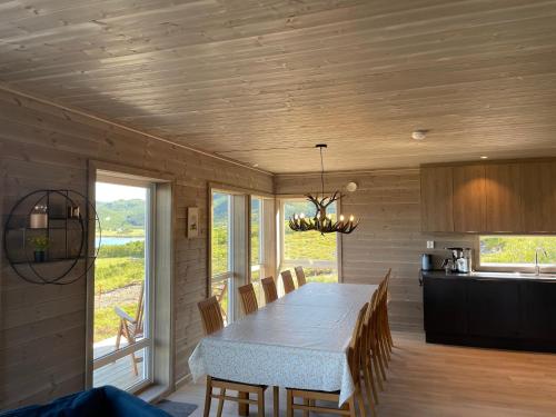 a dining room with a table and a kitchen at Lofotenholidays, Luxury cabin with panoramic view in Leknes