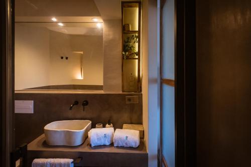a bathroom with a sink and a mirror and towels at K-TERRA by Nuka Homes in Jávea
