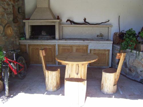 a wooden table and chairs in a kitchen with a stove at Casa Da Eira Longa in Vilar